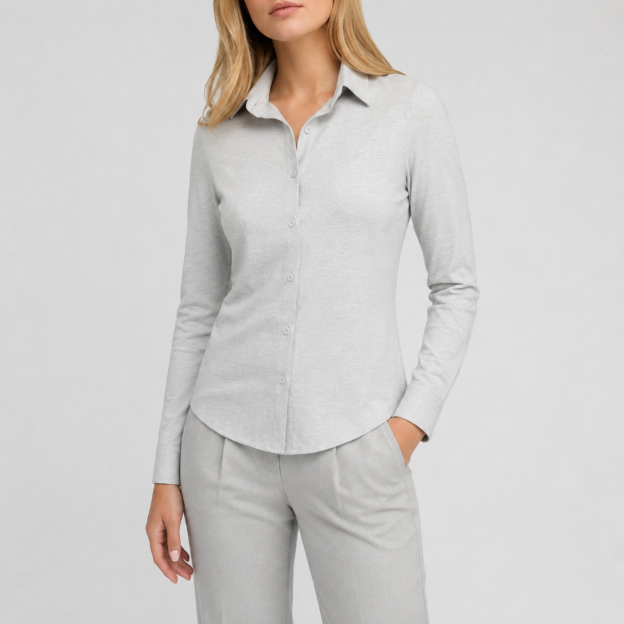 Long sleeve button-up shirt with collared neckline, tailored fit, and curved hem